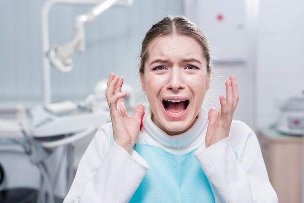 Porträt der jungen Frau erschrak am Zahnarzt