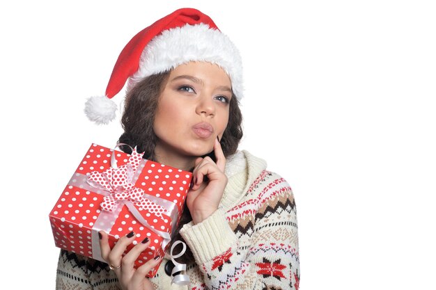 Porträt der jungen Frau in Weihnachtsmütze mit Geschenk auf weißem Hintergrund