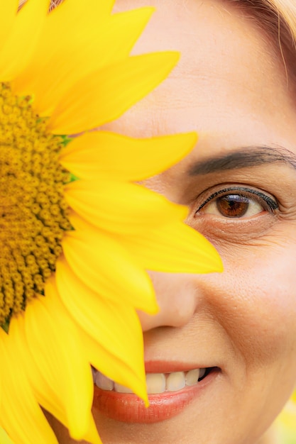 Porträt der jungen Frau mit Blumensonnenblume, Nahaufnahme, Sommersaison