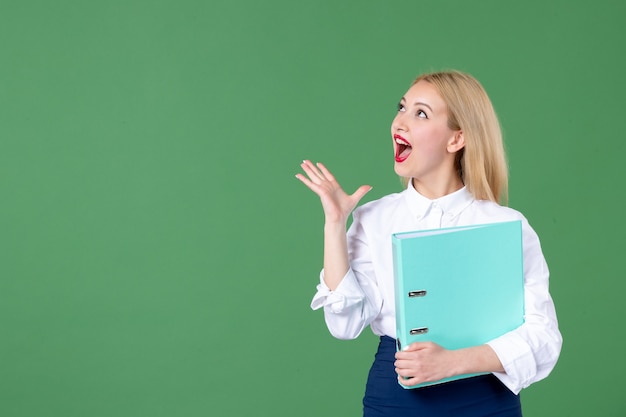 Porträt der jungen Frau mit Dokument grüne Wand Lehrer Schulstunde school