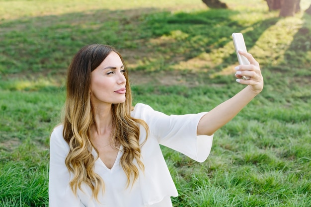 Porträt der jungen Frau selfie Foto im Park machend