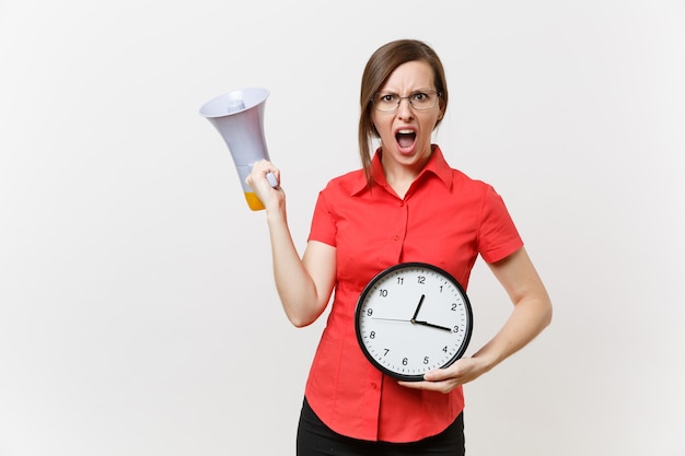 Porträt der jungen Geschäftslehrerfrau im roten Hemd, die runde Uhr hält, schreit im Megaphon, verkündet Rabattverkauf, lokalisiert auf weißem Hintergrund. Heiße Neuigkeiten, Kommunikationskonzept.. Beeilt euch, Leute