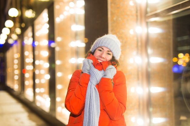 Porträt der jungen lustigen attraktiven Frau über schneebedeckten Weihnachtshintergrundwinterferien und -saison