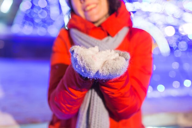 Porträt der jungen lustigen attraktiven Frau über schneebedeckten Weihnachtshintergrundwinterferien und -saison