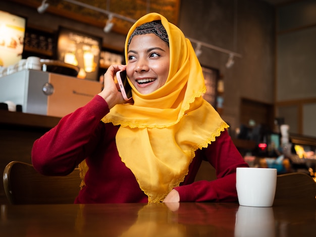 Porträt der jungen moslemischen Frau in der Kaffeestube