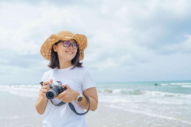 Porträt der jungen schönen asiatischen Frau entspannen in der Sonne am Strand nahe dem Meer.