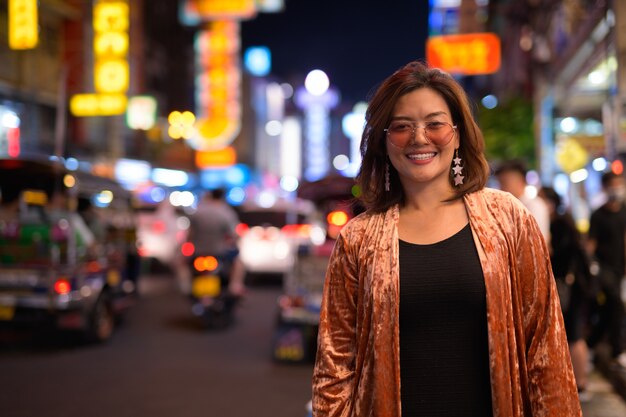 Porträt der jungen schönen asiatischen Touristenfrau, die Chinatown in Bangkok erkundet