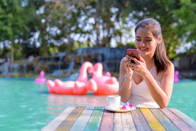 Porträt der jungen schönen asiatischen Touristenfrau, die durch den See draußen entspannt