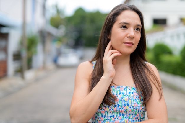 Porträt der jungen schönen Frau, die Sommerkleid in der Straße trägt