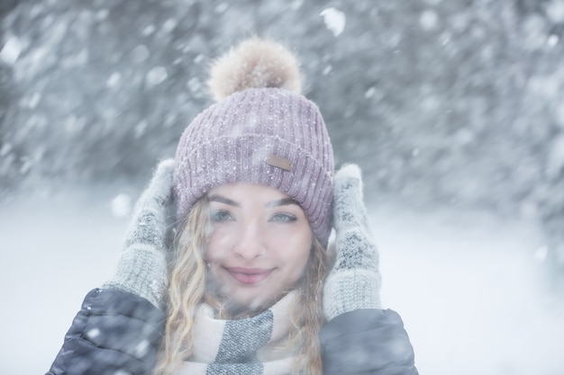 Porträt der jungen schönen Frau in Winterkleidung und starkem Schneefall.