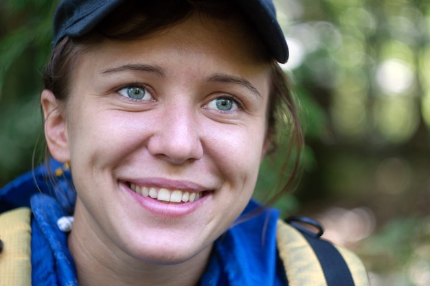 Porträt der jungen schönen lächelnden Frau ohne Make-up im Wald