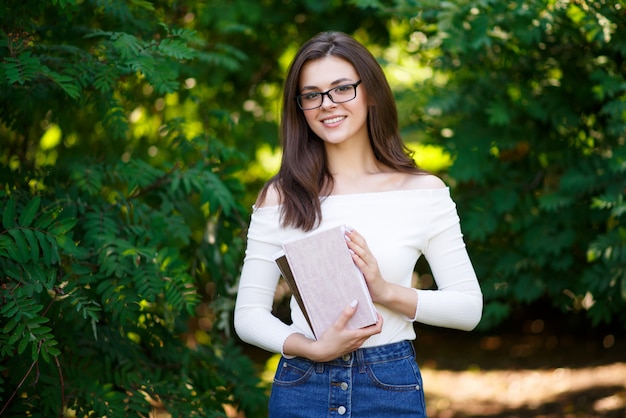 Porträt der jungen schönen Studentin mit Büchern