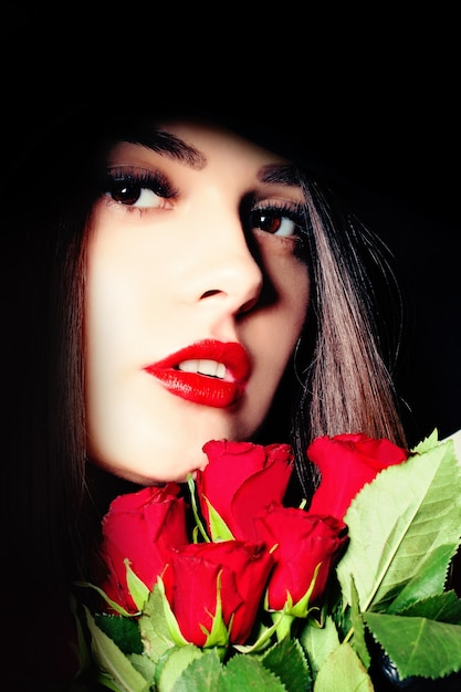 Porträt der jungen Schönheitsfrau mit roten Rosen-Blumen
