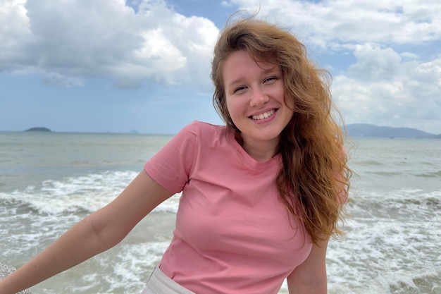 Porträt der jungen sorglosen Frau des schönen entspannten glücklichen positiven Mädchens genießt Seesommerferien, die Kamera lächelnd betrachten