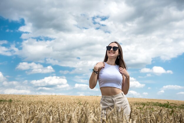 Porträt der jungen sportlichen Frau auf Weizenfeld im Sommer. Lebensstil