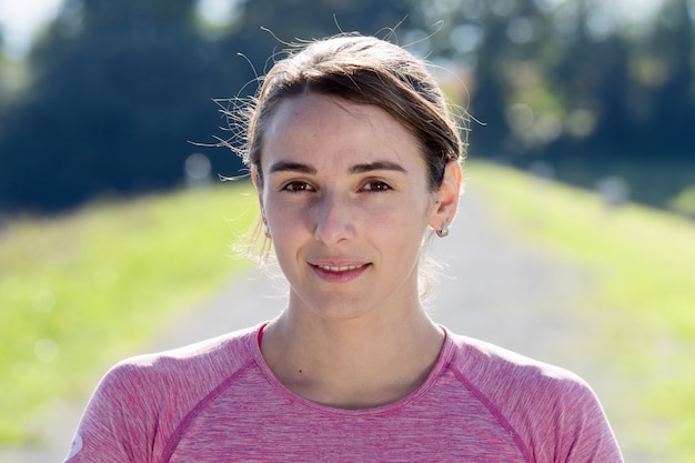 Porträt der jungen sportlichen Frau in der Landschaft