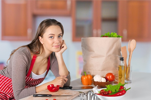 Porträt der jungen süßen Frau mit Essen im Hintergrund