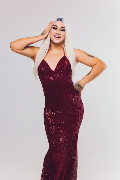 Porträt der jungen Transgenderfrau auf rotem Kleid mit Pailletten