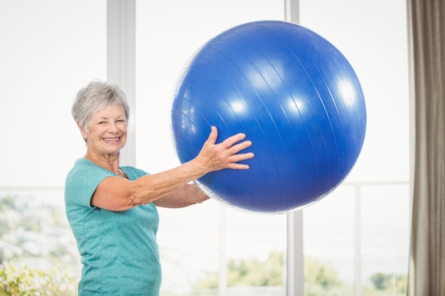 Porträt der lächelnden älteren Frau, die Übungsball hält