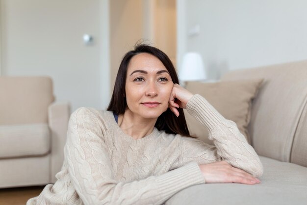 Porträt der lächelnden asiatischen Frau mittleren Alters, die die Kamera betrachtet Schöne Frau, die zu Hause lächelt