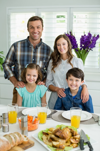 Porträt der lächelnden Familie, die zusammen auf Esstisch zu Mittag isst
