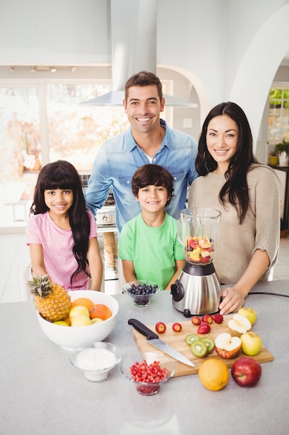 Porträt der lächelnden Familie Fruchtsaft zubereitend