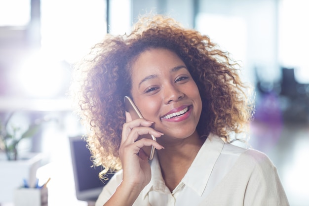 Porträt der lächelnden Frau, die am Telefon spricht