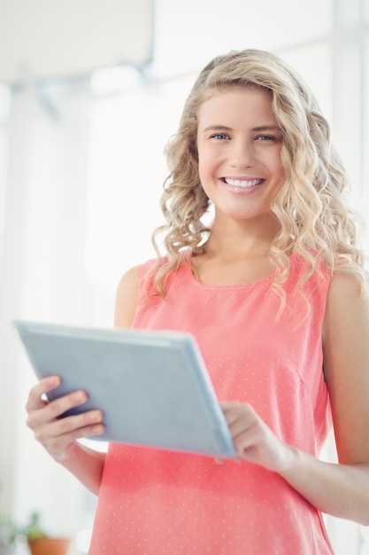 Porträt der lächelnden Frau, die digitale Tablette im Büro verwendet