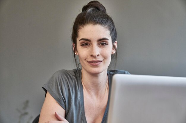 Porträt der lächelnden jungen Frau mit Laptop