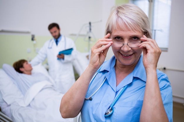 Porträt der lächelnden Krankenschwester, die Brille trägt