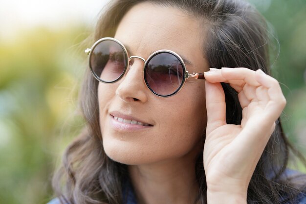 Porträt der lächelnden tragenden Sonnenbrille der Brunettefrau