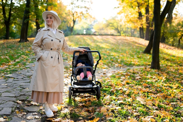 Porträt der Mutter mit Kinderwagen im Park