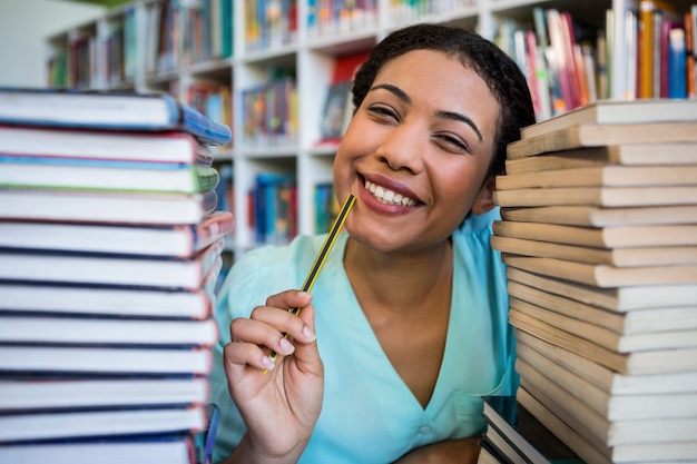 Porträt der nachdenklichen jungen Frau in der Bibliothek