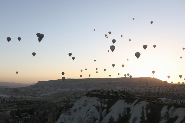 Porträt der Panoramalandschaft mit Heißluftballons, Sonnenaufgang und Bergen im Hintergrund