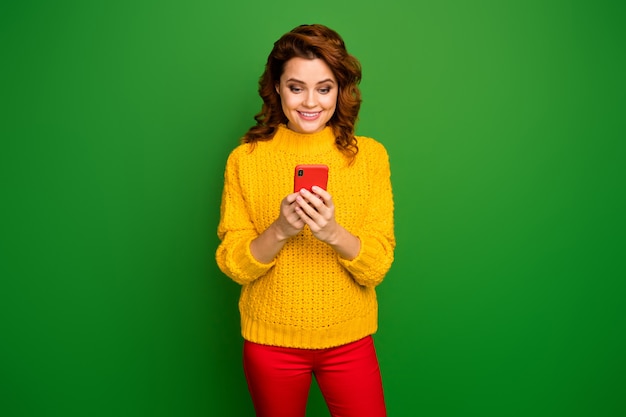 Porträt der positiven fröhlichen Frau verwenden Smartphone lesen Kommentar repost teilen soziale Netzwerknachrichten tragen Pullover isoliert über hellen Glanz Farbe Wand