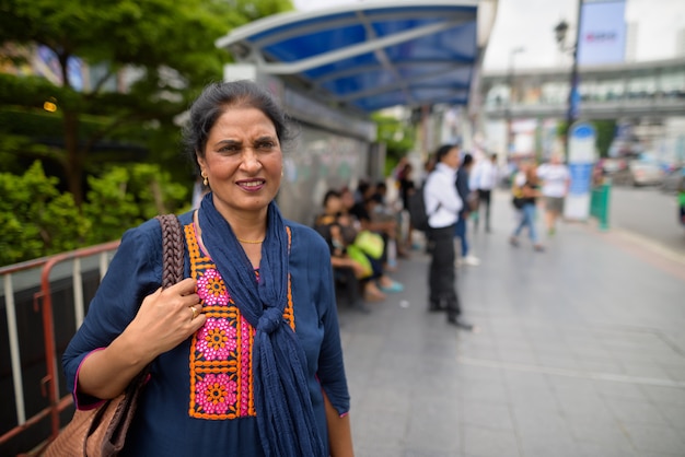 Porträt der reifen schönen indischen Frau, die die Stadt Bangkok, Thailand erkundet