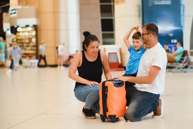 Porträt der reisenden Familie mit Koffern im Flughafen