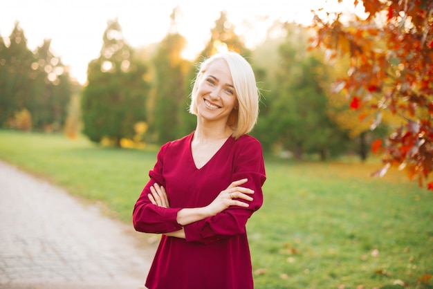 Porträt der reizenden jungen blonden Frau im Freien in der Natur in der Herbstzeit
