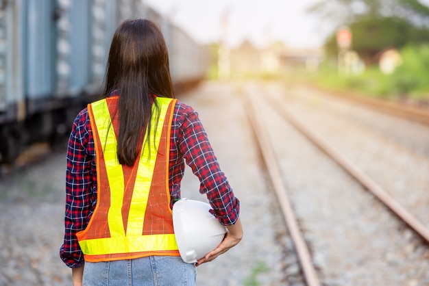 Porträt der Rückansichtstechnik mit Bauarbeiterhelm. Auftragnehmer auf dem Hintergrund von modernen Bahnhöfen im Freien.