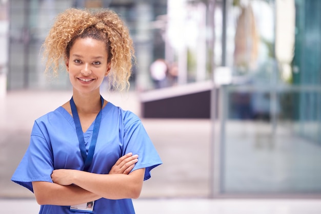 Porträt der Ärztin mit Scrubs im modernen Krankenhausgebäude