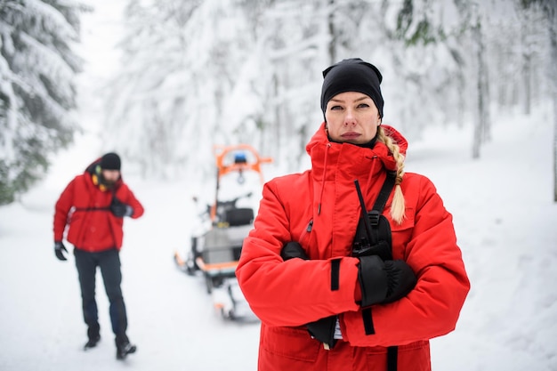 Porträt der Sanitäterin vom Bergrettungsdienst draußen im Winter im Wald