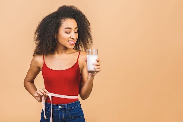 Porträt der schönen Afroamerikanerfrau mit Glas Milch