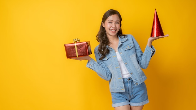 Porträt der schönen asiatischen Frau, die Hut und Geschenkbox hält