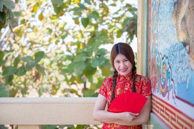 Porträt der schönen asiatischen Frau im Cheongsam-KleidThailänderFröhliches chinesisches Neujahrskonzept