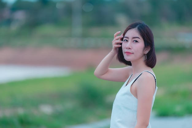 Porträt der schönen asiatischen Frau mit goldenen Haaren im FreienGlückliches FrauenkonzeptLebensstil des modernen MädchensThailänderPastellton