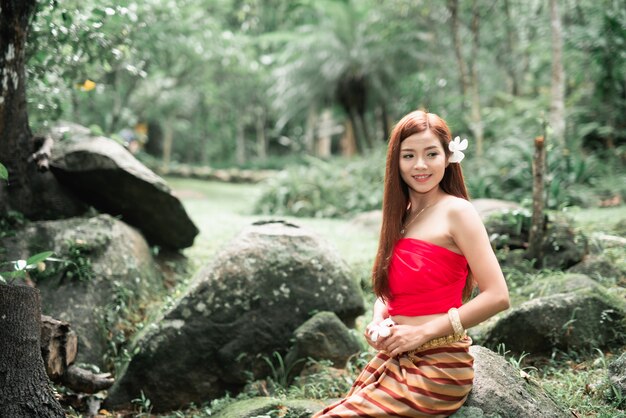 Porträt der schönen asiatischen Frauen am Wasserfall im Dschungel