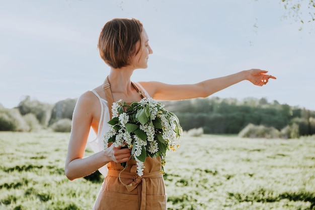 Porträt der schönen Frau, die Kranz aus Blumen Löwenzahn auf blühendem Feld macht Sommer-Lifestyle-Naturliebhaber und Freiheitskonzept Floristen-Workshop Romantischer Hintergrund des Floristen bei der Arbeit