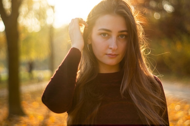 Porträt der schönen Frau und Blick weg auf Park während des Sonnenuntergangs