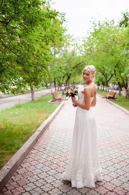 Porträt der schönen glücklichen Braut mit Hochzeits-Make-up und Hochzeitsfrisur im Hochzeitskleid