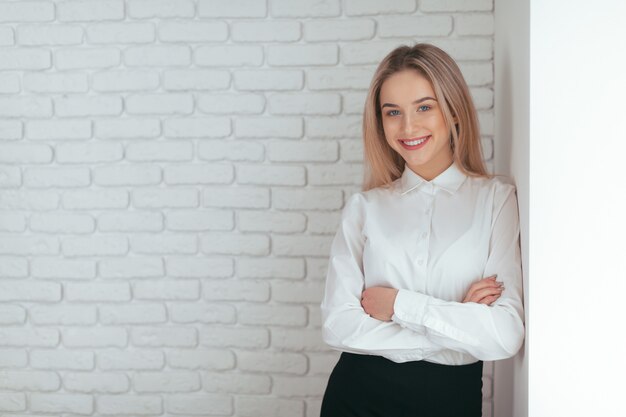 Porträt der schönen jungen Frau, die im Büro arbeitet.